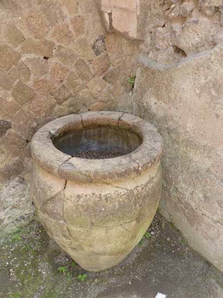 V.10, Herculaneum, May 2010. Large terracotta pot in south-east corner of shop-room.